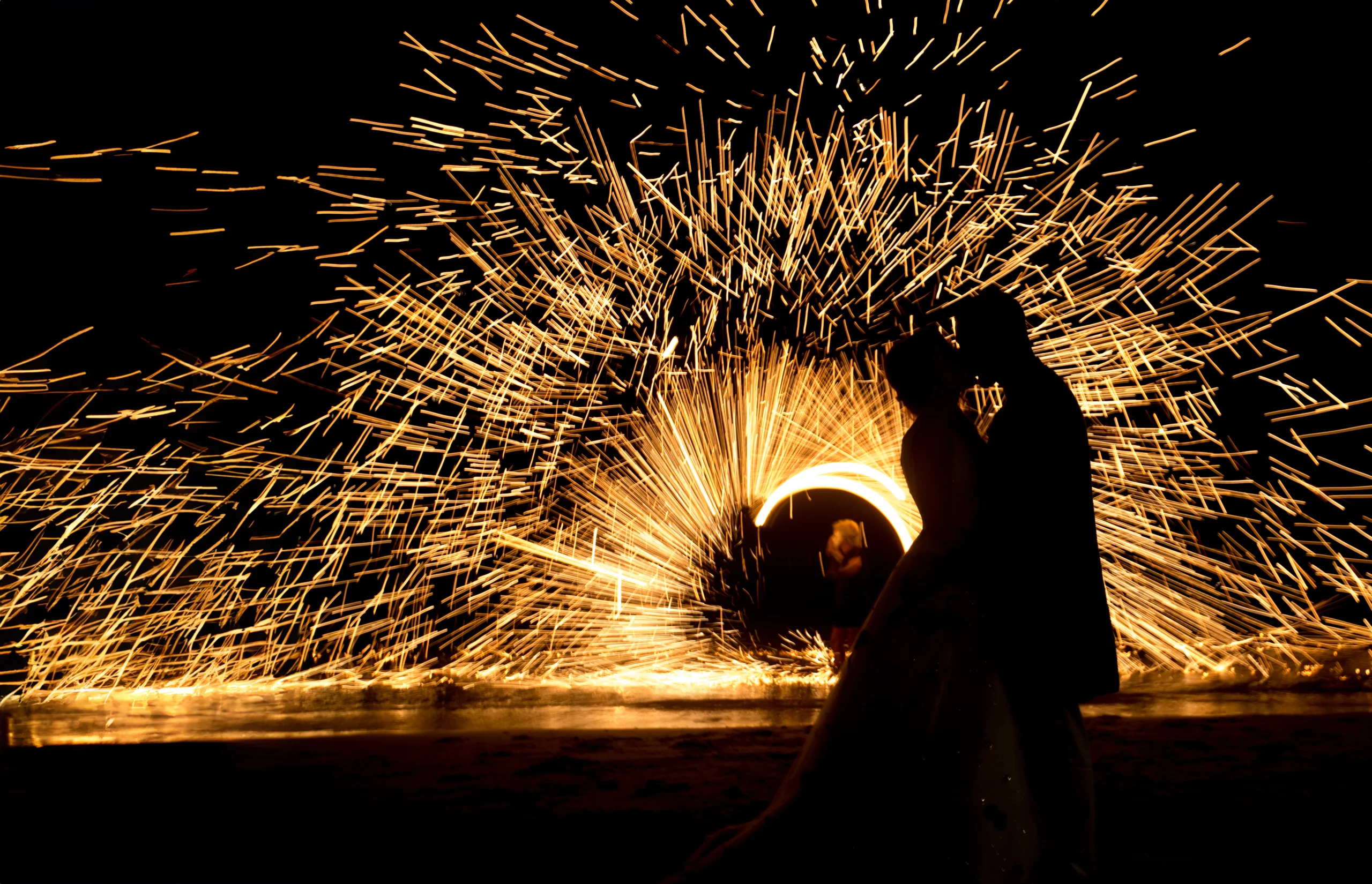 Spettacolo di fuoco per matrimoni Gli sposi si baciano mentre l'acrobata fa roteare catene infuocate creando favolosi giochi di luce